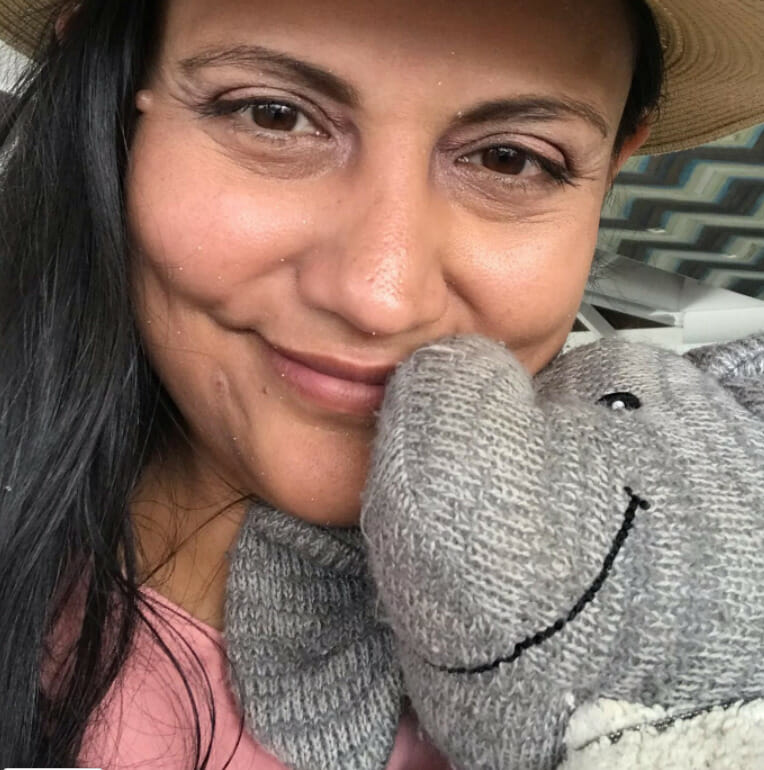 Closeup of Miranda holding Adrian's Elephant. Miranda is wearing a pink dress and tan floppy hat (personal photo)